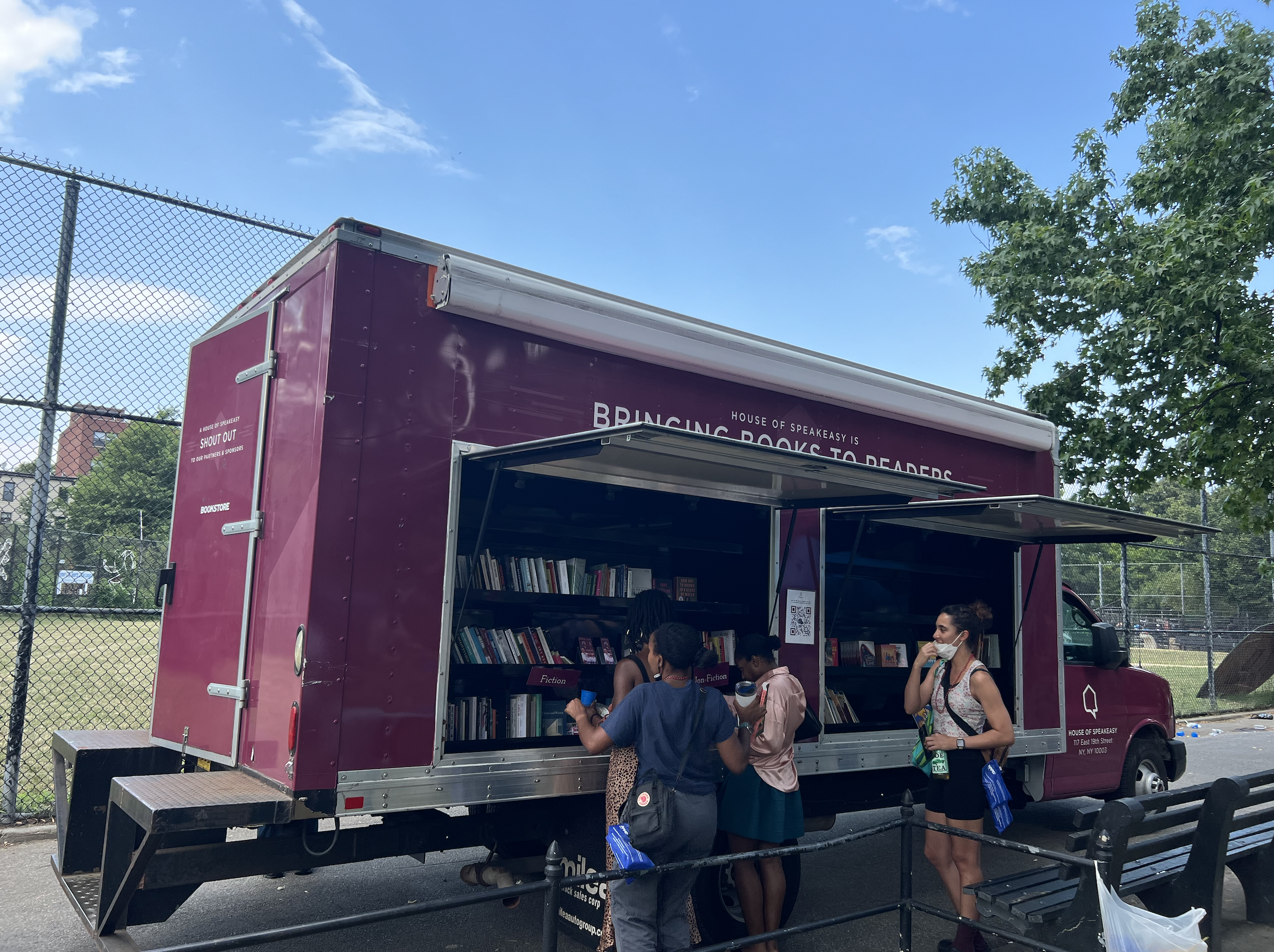 A crowd of young children gathers around House of SpeakEasy's Bookmobile